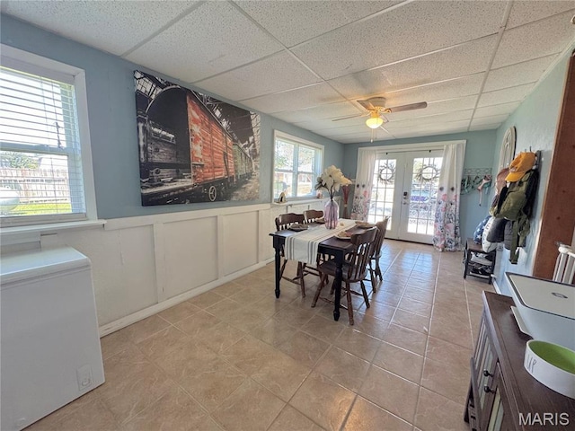 56319 Meyer Trl, Hannibal, MO 63401 - dining area with a paneled ceiling, french doors, wainscoting, a ceiling fan, and light tile patterned floors