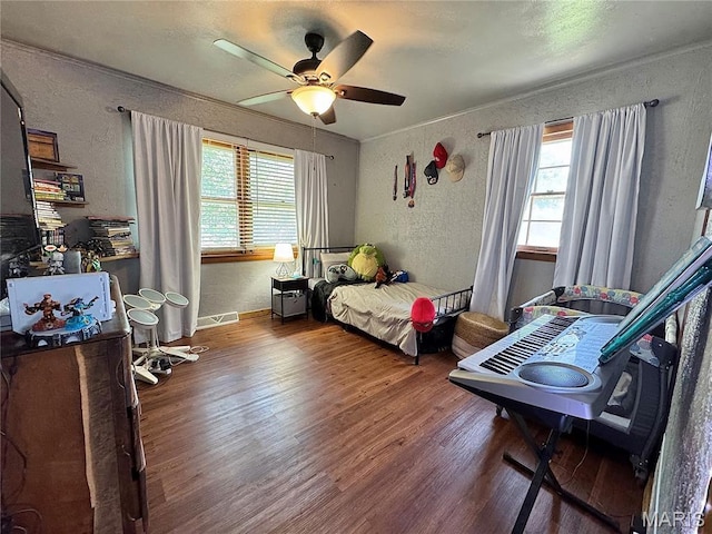 56319 Meyer Trl, Hannibal, MO 63401 - bedroom featuring a textured wall, multiple windows, wood finished floors, and a ceiling fan
