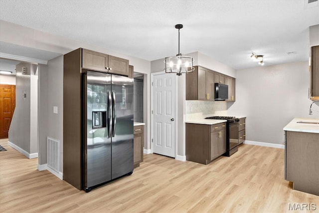 525 Homestead Ave, Swansea, IL 62226 - kitchen featuring black appliances, light wood-style flooring, light countertops, backsplash, and a chandelier