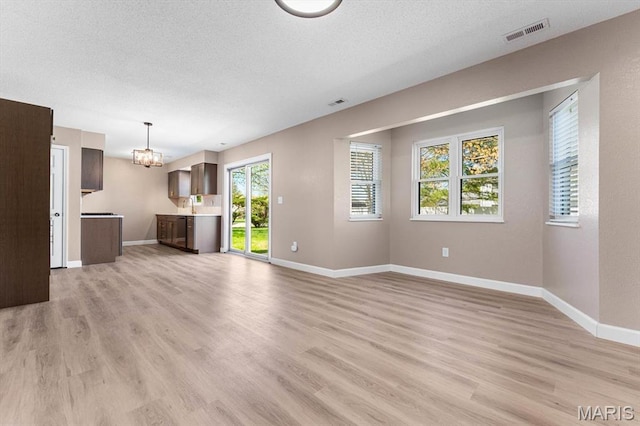 525 Homestead Ave, Swansea, IL 62226 - unfurnished living room with a chandelier, light wood finished floors, and a textured ceiling