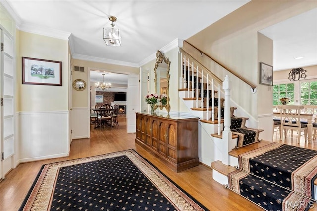 1843 Manor Hill Rd, Saint Louis, MO 63131 - entrance foyer featuring a chandelier, wood finished floors, stairway, wainscoting, and ornamental molding