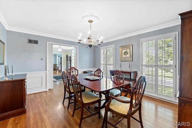 1843 Manor Hill Rd, Saint Louis, MO 63131 - dining area with crown molding, wood finished floors, a chandelier, and wainscoting