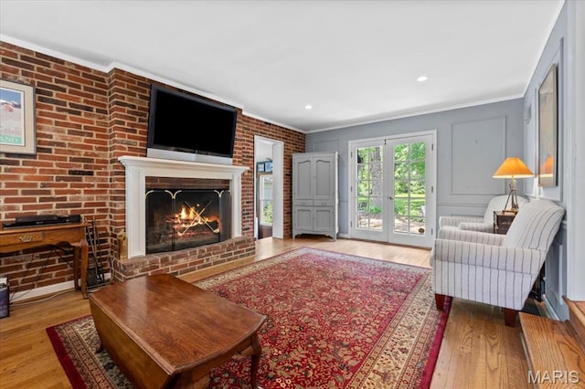 1843 Manor Hill Rd, Saint Louis, MO 63131 - living area with a brick fireplace, crown molding, wood finished floors, and french doors
