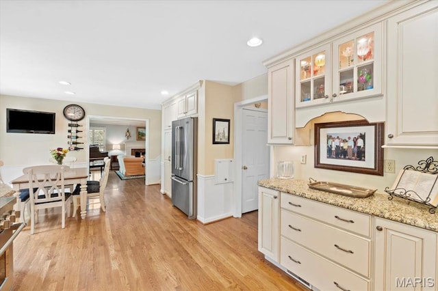 1843 Manor Hill Rd, Saint Louis, MO 63131 - kitchen with freestanding refrigerator, light stone countertops, glass insert cabinets, light wood-type flooring, and recessed lighting