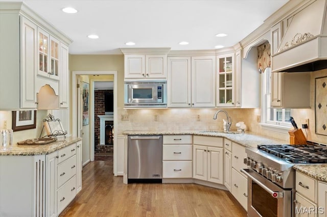1843 Manor Hill Rd, Saint Louis, MO 63131 - kitchen featuring stainless steel appliances, light wood-style flooring, decorative backsplash, light stone counters, and recessed lighting