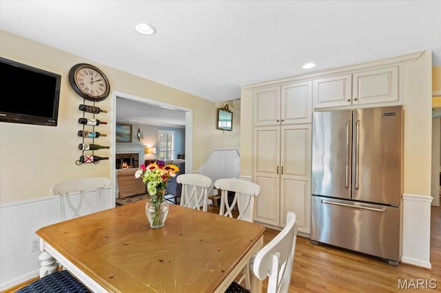 1843 Manor Hill Rd, Saint Louis, MO 63131 - dining space featuring wainscoting, light wood-type flooring, recessed lighting, and a brick fireplace