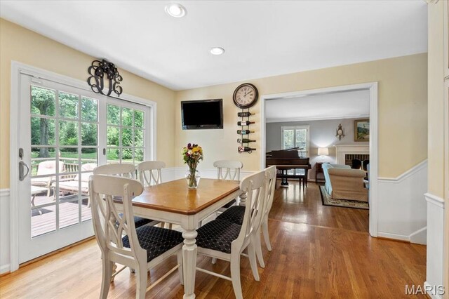 1843 Manor Hill Rd, Saint Louis, MO 63131 - dining room featuring light wood-style floors, a lit fireplace, wainscoting, and recessed lighting