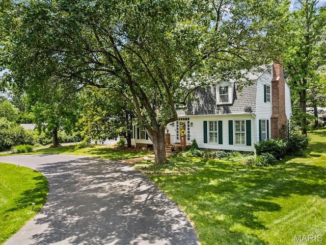 1843 Manor Hill Rd, Saint Louis, MO 63131 - view of front facade featuring a front yard, a chimney, asphalt driveway, and a gambrel roof