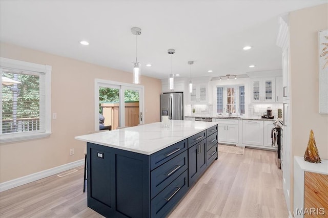 447 Maymont Dr, Ballwin, MO 63011 - kitchen featuring stainless steel fridge with ice dispenser, white cabinetry, light wood-type flooring, glass insert cabinets, and recessed lighting