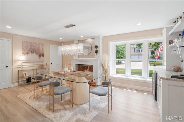 447 Maymont Dr, Ballwin, MO 63011 - dining area featuring light wood-type flooring, a lit fireplace, and recessed lighting