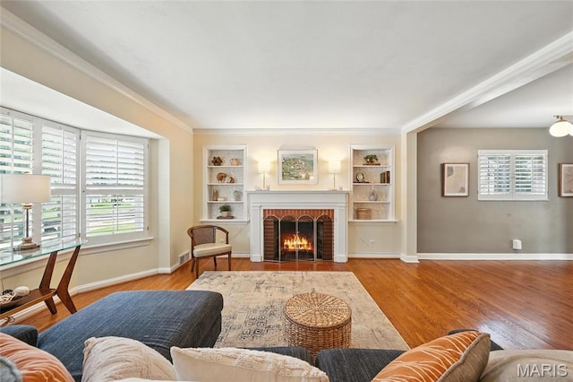 906 N Taylor Ave, Saint Louis, MO 63122 - living area with healthy amount of natural light, wood finished floors, built in shelves, and ornamental molding