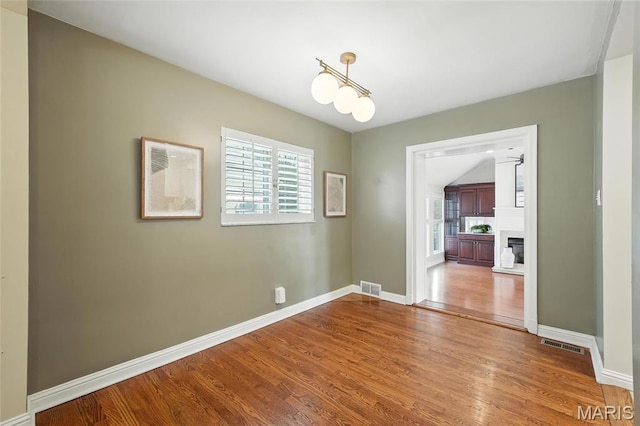 906 N Taylor Ave, Saint Louis, MO 63122 - unfurnished dining area featuring wood finished floors and a fireplace