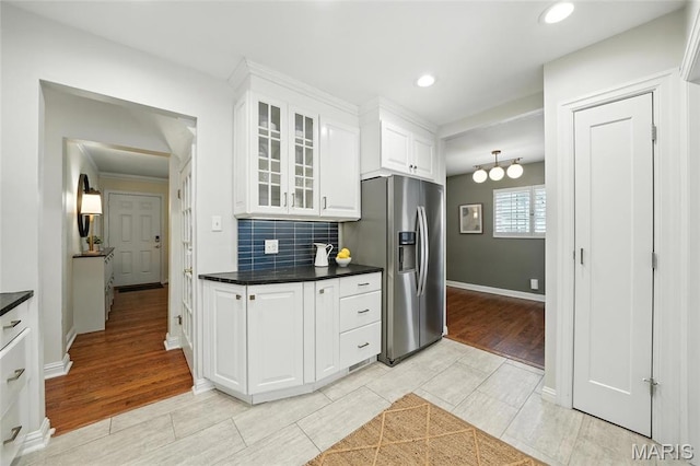 906 N Taylor Ave, Saint Louis, MO 63122 - kitchen with stainless steel refrigerator with ice dispenser, glass insert cabinets, dark countertops, white cabinetry, and backsplash