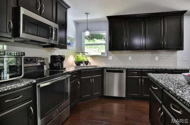3375 Amber Heights Ln, Imperial, MO 63052 - kitchen with appliances with stainless steel finishes, dark wood-type flooring, dark stone counters, dark cabinetry, and tasteful backsplash