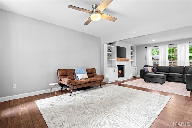 1026 Timber Creek Ln, Ofallon, IL 62269 - living room with a lit fireplace, a ceiling fan, wood finished floors, and built in features