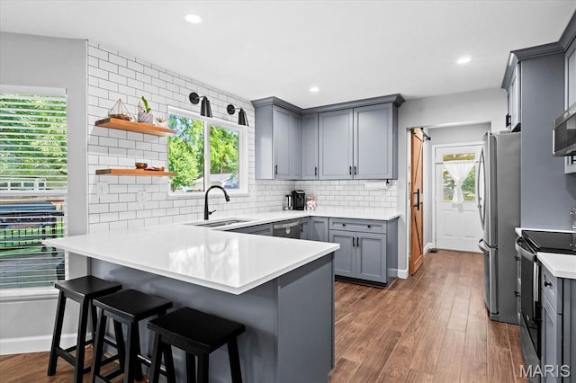 1026 Timber Creek Ln, Ofallon, IL 62269 - kitchen with stainless steel appliances, gray cabinets, a peninsula, plenty of natural light, and recessed lighting