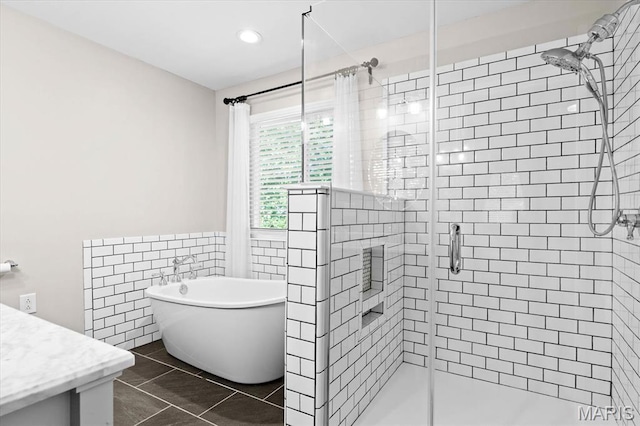 1026 Timber Creek Ln, Ofallon, IL 62269 - bathroom featuring a stall shower, a freestanding tub, vanity, tile walls, and tile patterned floors