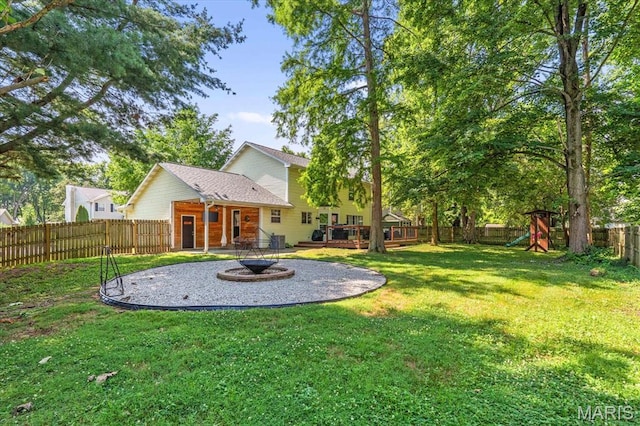 1026 Timber Creek Ln, Ofallon, IL 62269 - fenced backyard with a playground, an outdoor fire pit, and a deck