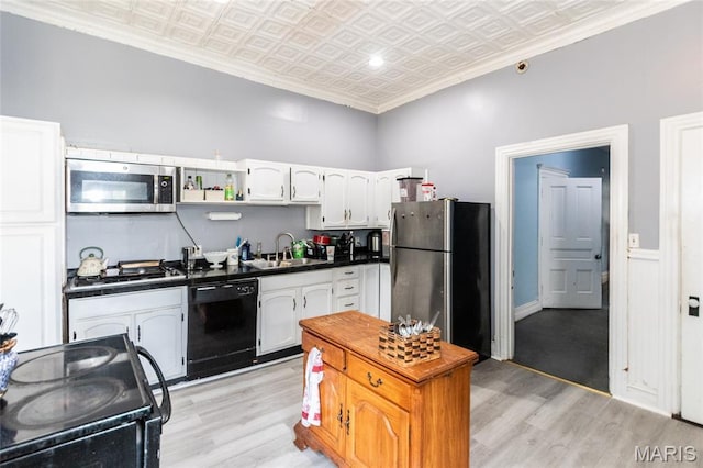 3815 N 20th St, Saint Louis, MO 63107 - kitchen featuring stainless steel appliances, an ornate ceiling, dark countertops, light wood-type flooring, and white cabinets