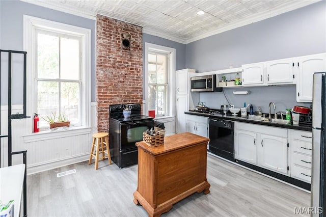 3815 N 20th St, Saint Louis, MO 63107 - kitchen featuring black appliances, an ornate ceiling, dark countertops, white cabinetry, and light wood-style floors