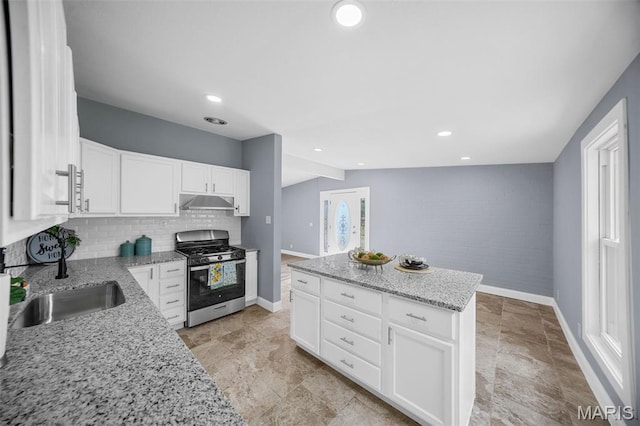 6822 Friarwood Dr, Saint Louis, MO 63134 - kitchen featuring stainless steel gas range, under cabinet range hood, backsplash, white cabinetry, and light stone countertops