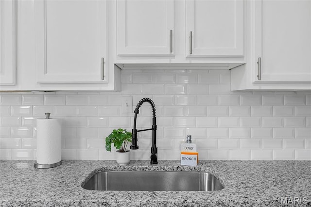 6822 Friarwood Dr, Saint Louis, MO 63134 - kitchen view of white cabinets, tasteful backsplash, and light stone counters