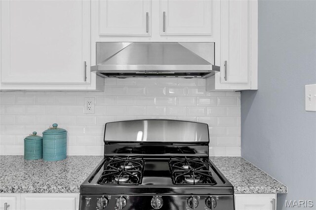 6822 Friarwood Dr, Saint Louis, MO 63134 - kitchen featuring black range with gas stovetop, ventilation hood, white cabinets, and tasteful backsplash