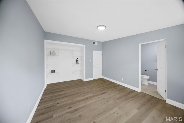 6822 Friarwood Dr, Saint Louis, MO 63134 - unfurnished bedroom with wood finished floors, ensuite bathroom, and a closet