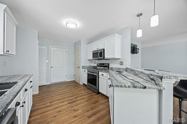 3112 Bentwater Pl, Saint Charles, MO 63301 - kitchen featuring appliances with stainless steel finishes, a breakfast bar, white cabinetry, and dark wood-style flooring
