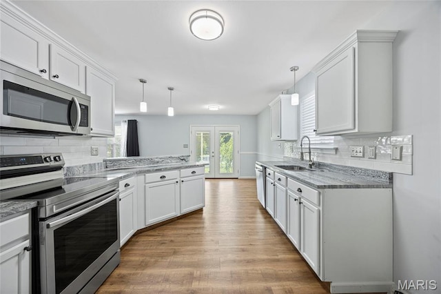 3112 Bentwater Pl, Saint Charles, MO 63301 - kitchen with appliances with stainless steel finishes, wood finished floors, a peninsula, and white cabinetry