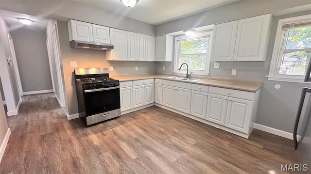 6613 Dunwold Dr, Saint Louis, MO 63134 - kitchen featuring stainless steel gas stove, under cabinet range hood, wood finished floors, and healthy amount of natural light