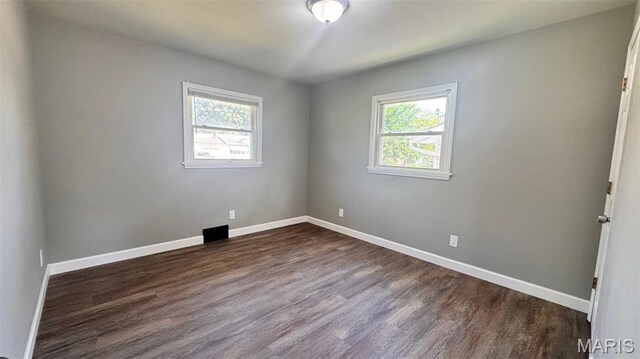 6613 Dunwold Dr, Saint Louis, MO 63134 - empty room with healthy amount of natural light and dark wood-type flooring