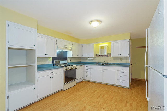 517 E 2nd St, Rolla, MO 65401 - kitchen featuring white range with gas cooktop, freestanding refrigerator, under cabinet range hood, light wood finished floors, and decorative backsplash
