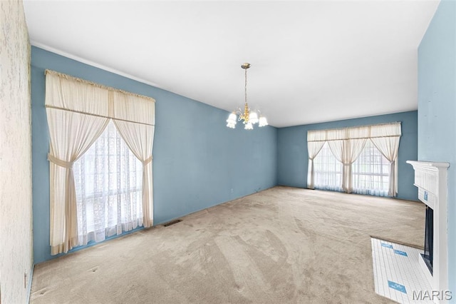 670 Gateswood Dr, Florissant, MO 63033 - unfurnished living room featuring a chandelier, carpet flooring, and a fireplace