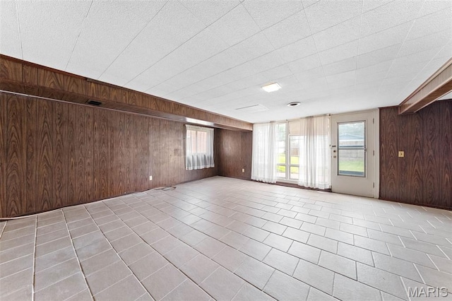 670 Gateswood Dr, Florissant, MO 63033 - unfurnished room with wooden walls, tile patterned floors, and healthy amount of natural light