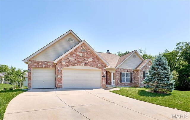 5 Tucker Manor Ct, Wentzville, MO 63385 - view of front facade featuring brick siding, an attached garage, a front yard, and concrete driveway