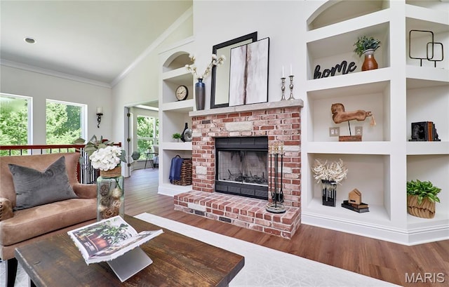5 Tucker Manor Ct, Wentzville, MO 63385 - living area featuring built in shelves, wood finished floors, ornamental molding, a fireplace, and high vaulted ceiling