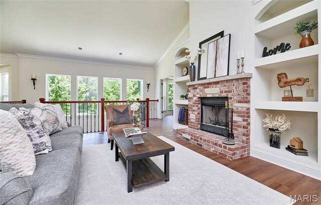 5 Tucker Manor Ct, Wentzville, MO 63385 - living room featuring built in features, healthy amount of natural light, wood finished floors, crown molding, and a brick fireplace