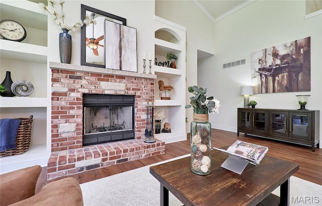 5 Tucker Manor Ct, Wentzville, MO 63385 - living area with a fireplace, built in features, wood finished floors, crown molding, and high vaulted ceiling