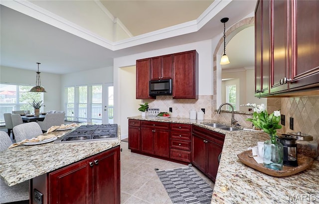 5 Tucker Manor Ct, Wentzville, MO 63385 - kitchen featuring reddish brown cabinets, stainless steel gas stovetop, black microwave, plenty of natural light, and vaulted ceiling