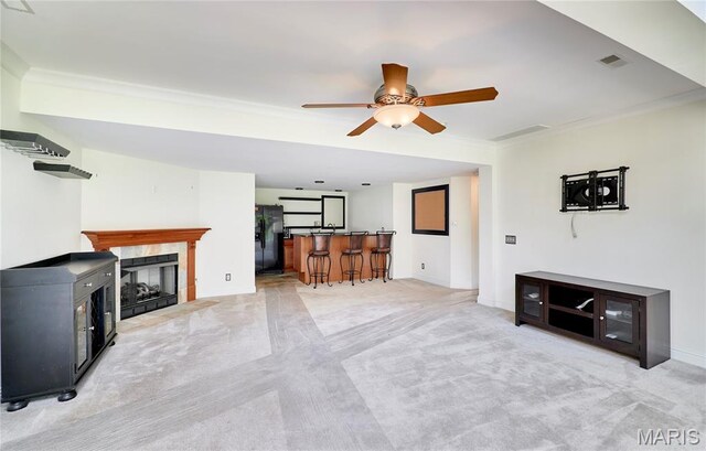 5 Tucker Manor Ct, Wentzville, MO 63385 - living area with light carpet, ornamental molding, a ceiling fan, a tiled fireplace, and bar area