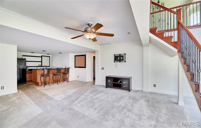 5 Tucker Manor Ct, Wentzville, MO 63385 - living room with wet bar, light colored carpet, a ceiling fan, stairway, and crown molding