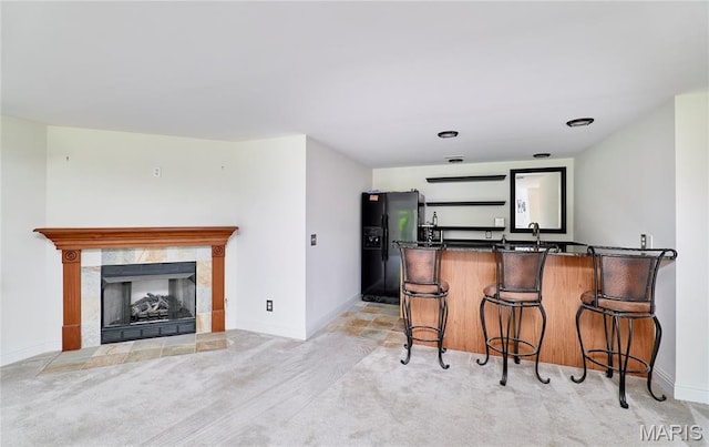 5 Tucker Manor Ct, Wentzville, MO 63385 - kitchen with black refrigerator with ice dispenser, light carpet, dark countertops, and a breakfast bar