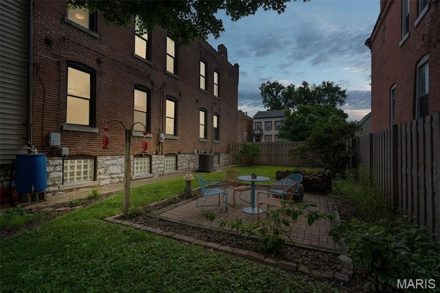 6505 Michigan Ave, Saint Louis, MO 63111 - yard at dusk featuring a fenced backyard and a patio area