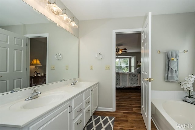 7202 Geneva Manor Ct, Oakville Township, MO 63129 - ensuite bathroom featuring double vanity, wood finished floors, a bath, and ceiling fan