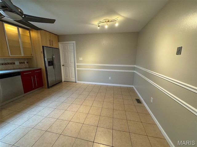 12383 Woodline Dr, Saint Louis, MO 63141 - kitchen featuring stainless steel appliances, backsplash, light tile patterned floors, ceiling fan, and dark countertops