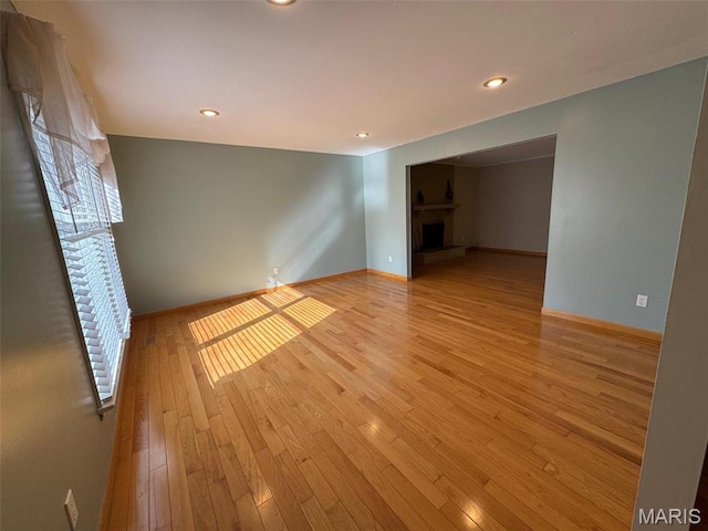 12383 Woodline Dr, Saint Louis, MO 63141 - unfurnished room with a fireplace with raised hearth, light wood-style floors, and recessed lighting