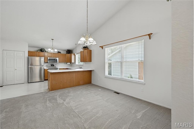 1516 Lienemann Dr Unit 26, Saint Charles, MO 63303 - kitchen with stainless steel appliances, a chandelier, brown cabinets, light countertops, and decorative light fixtures