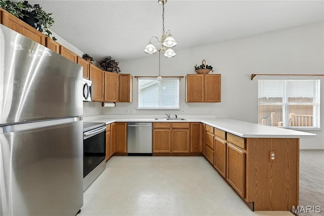 1516 Lienemann Dr Unit 26, Saint Charles, MO 63303 - kitchen featuring stainless steel appliances, a peninsula, brown cabinets, light countertops, and lofted ceiling