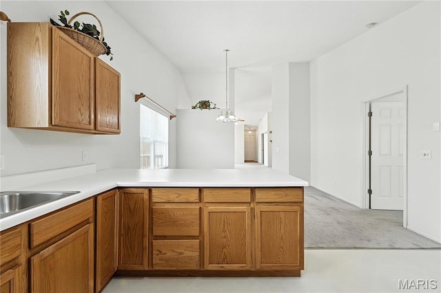1516 Lienemann Dr Unit 26, Saint Charles, MO 63303 - kitchen with a peninsula, brown cabinets, light colored carpet, and hanging light fixtures